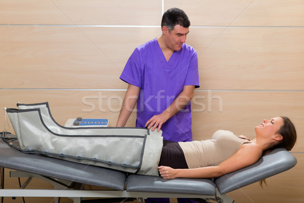 Doctor checking legs pressotherapy machine on woman Stock photo © lunamarina