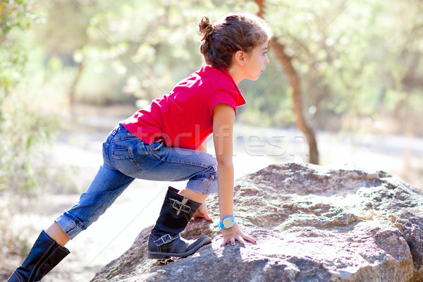 Hiking little girl climbing a rock in forest Stock photo © lunamarina