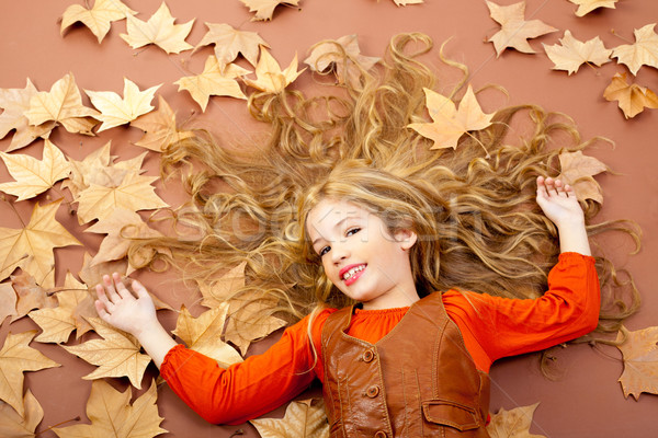 autumn fall little blond girl on dried tree leaves Stock photo © lunamarina
