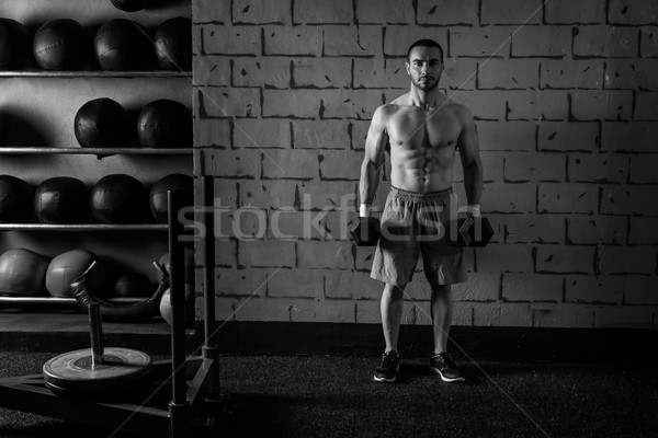 Stock photo: gym man holding hex dumbbells with muscles