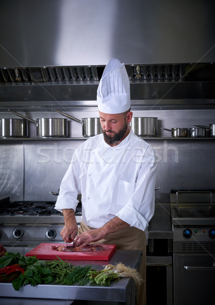 Chef cutting meat in restaurant kitchen Stock photo © lunamarina