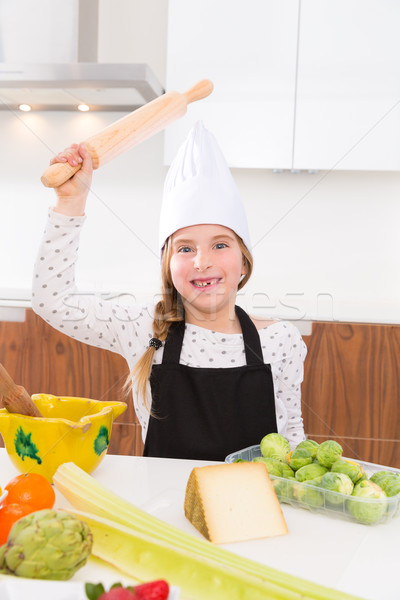 kid girl chef on countertop funny gesture with roller knead Stock photo © lunamarina