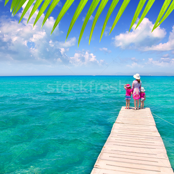 Daughters and mother in jetty on tropical beach Stock photo © lunamarina