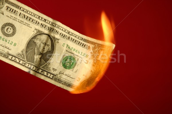 Dollar note burning in fire over red Stock photo © lunamarina