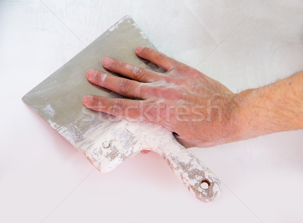 Plastering wall with plaste and plaster spatula trowel Stock photo © lunamarina