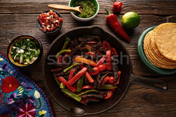 Stock photo: Beef fajitas in a pan with sauces Mexican food