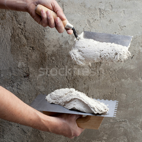construction notched trowel and worker hands Stock photo © lunamarina