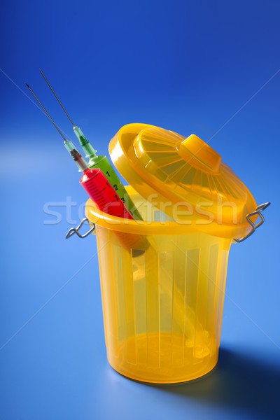 Two red and green syringe on the trash Stock photo © lunamarina