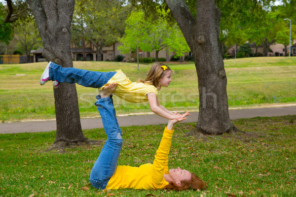 Daughter and mother playing keep balance lying on park Stock photo © lunamarina