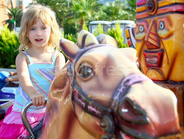 blond girl with fairground horse enjoy in park Stock photo © lunamarina