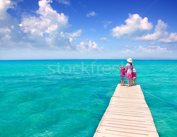 Daughters and mother in jetty on tropical beach Stock photo © lunamarina