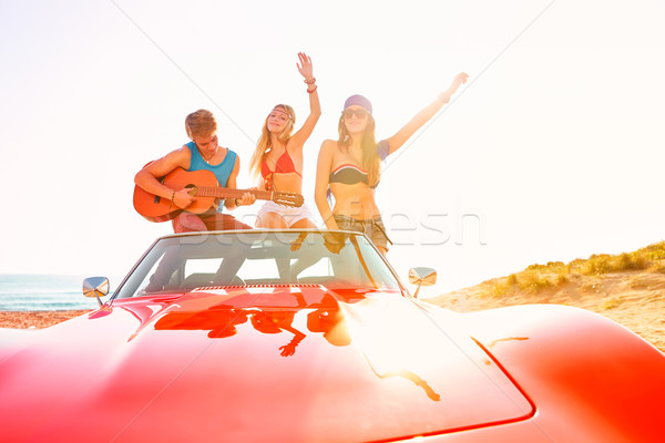 Stock photo: young group having fun on beach playing guitar