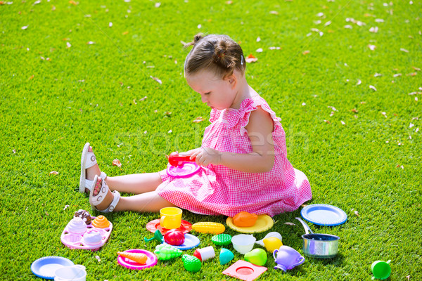 Toddler kid girl playing with food toys sitting in turf Stock photo © lunamarina