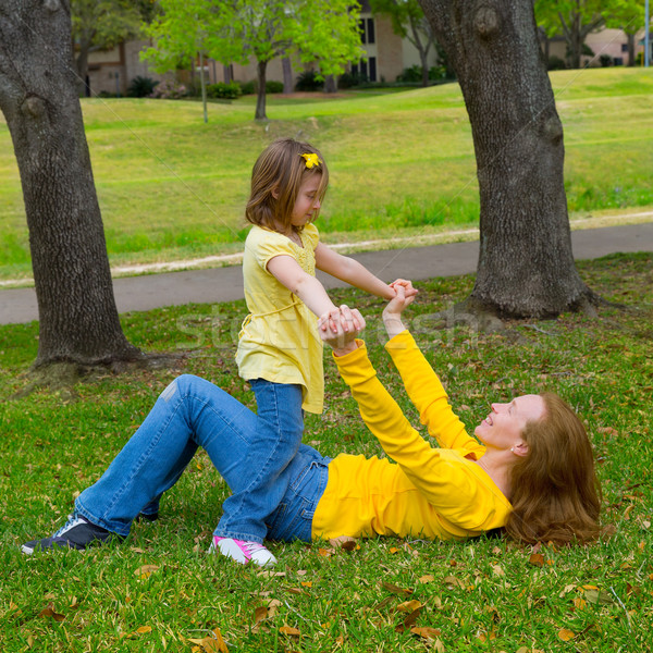 Daughter and mother playing lying on park lawn Stock photo © lunamarina