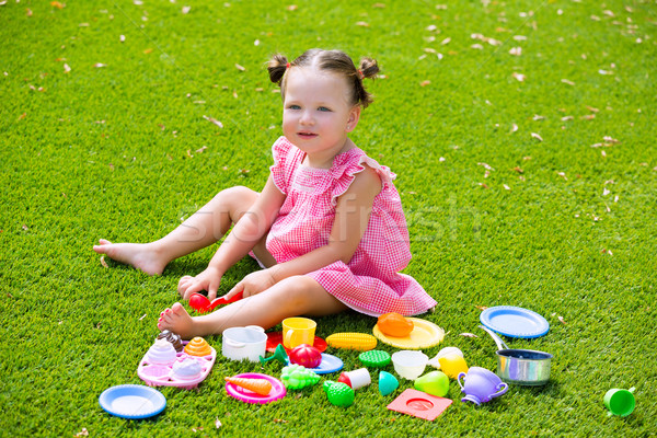 Toddler kid girl playing with food toys sitting in turf Stock photo © lunamarina