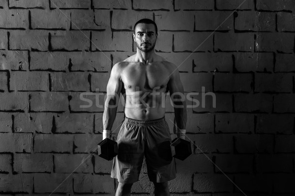 gym man holding hex dumbbells with muscles Stock photo © lunamarina