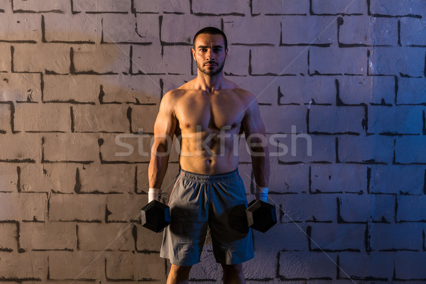 gym man holding hex dumbbells with muscles Stock photo © lunamarina