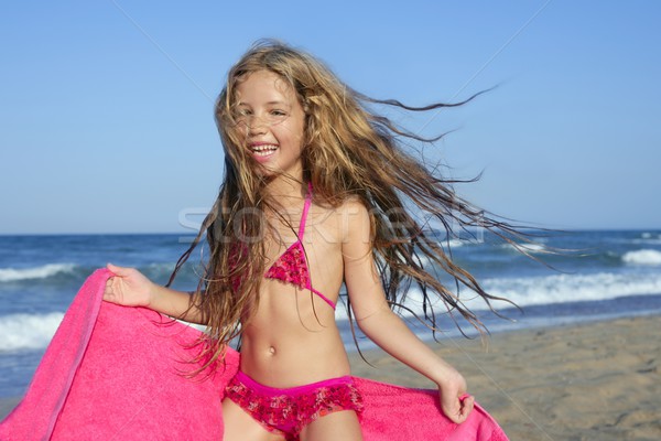 Маленькая девочка, играя на пляже.