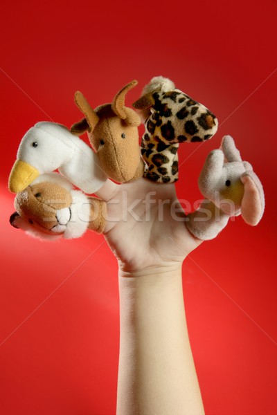 Finger puppets on a toddler hand over red Stock photo © lunamarina