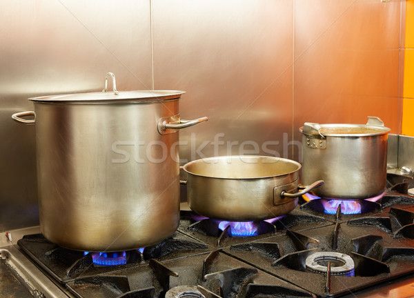 Restaurant pro kitchen with steel pans in fire Stock photo © lunamarina