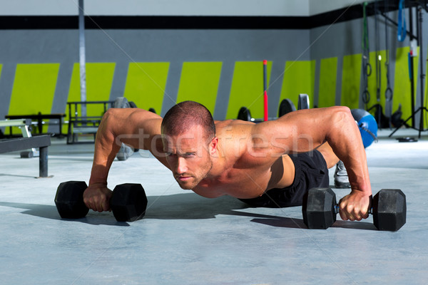 Gym man push-up strength pushup exercise with dumbbell Stock photo © lunamarina