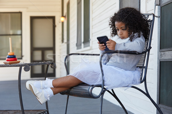 [[stock_photo]]: Kid · fille · séance · porche · jouer · smartphone