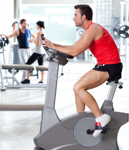 Stock photo: man on stationary bicycle at sport fitness gym
