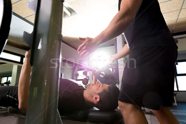 Bench press weightlifting man with personal trainer Stock photo © lunamarina