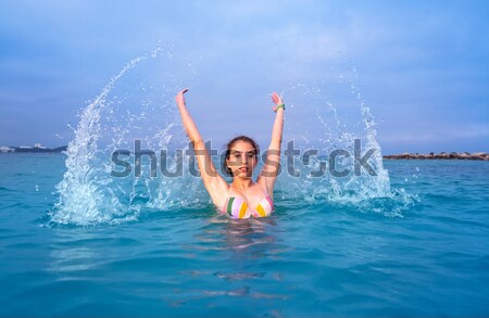 Biquíni menina saltando caribbean pôr do sol praia Foto stock © lunamarina