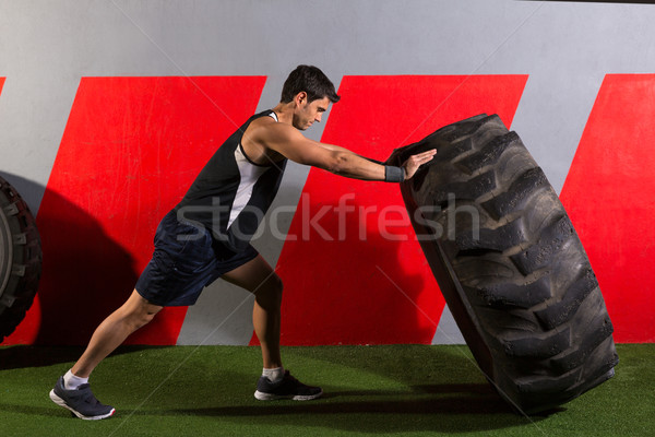  man flipping a tractor tire workout gym exercise Stock photo © lunamarina