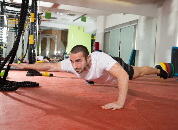 Crossfit fitness man balance pus ups with one leg and arm Stock photo © lunamarina