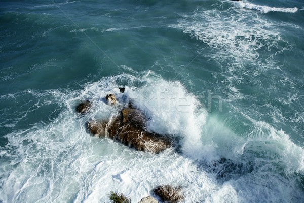 Angry stormy sea waves reaching a big stone and splash water Stock photo © lunamarina