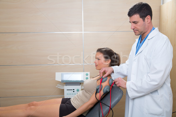 Doctor therapist checking muscle electrostimulation to woman Stock photo © lunamarina