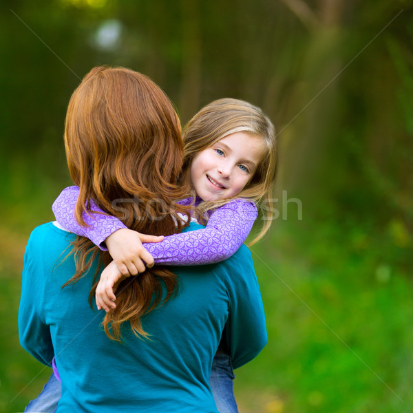 Mum holding daughter kid girl in her arms rear view smiling Stock photo © lunamarina