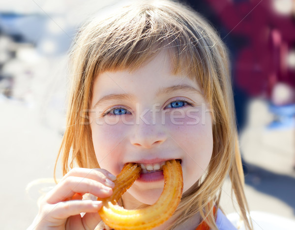 Blue eyes little girl eating churros smiling Stock photo © lunamarina