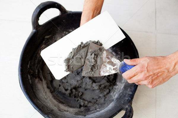 Zidar lucrător mâini ciment găleată Imagine de stoc © lunamarina