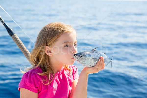 Stock photo: Blond kid girl fishing tuna little tunny kissing for release