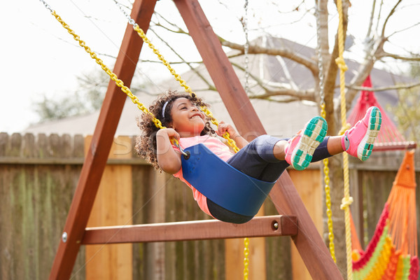 Kid toddler girl swinging on a playground swing Stock photo © lunamarina