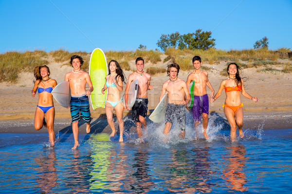 Stock photo: Teen surfers group running beach splashing