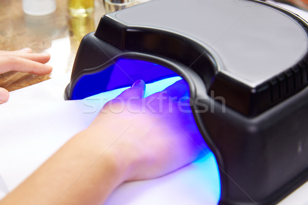 Nails painting with UV dry lamp in blue light Stock photo © lunamarina