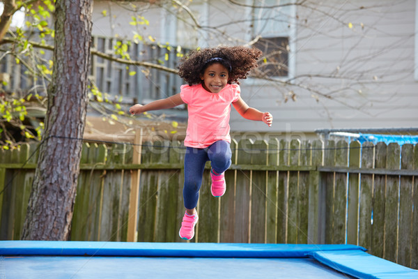 Kid toddler girl jumping on a trampoline Stock photo © lunamarina