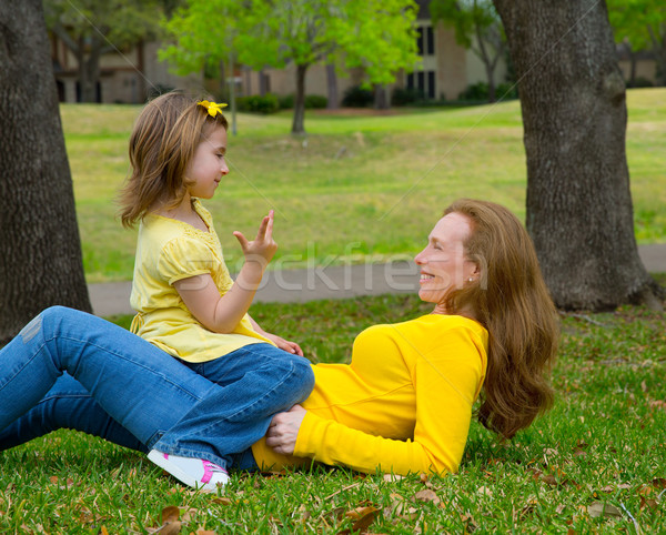 Daughter and mother playing counting lying on lawn Stock photo © lunamarina
