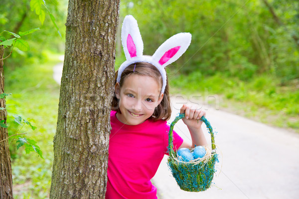 Easter girl with eggs basket and funny bunny face Stock photo © lunamarina