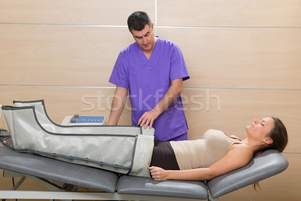 Stock photo: Doctor checking legs pressotherapy machine on woman