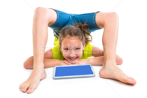 Flexible contortionist kid girl playing with tablet pc Stock photo © lunamarina