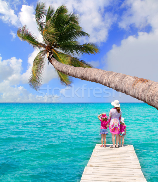 Daughters and mother in jetty on tropical beach Stock photo © lunamarina