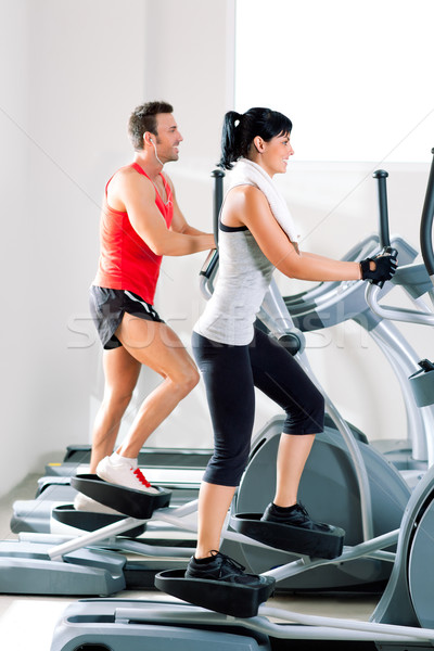 man and woman with elliptical cross trainer at gym Stock photo © lunamarina