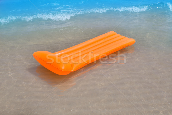 Beach shore with orange floating lounge and waves Stock photo © lunamarina