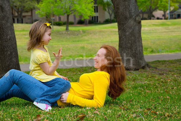 Daughter and mother playing counting lying on lawn Stock photo © lunamarina