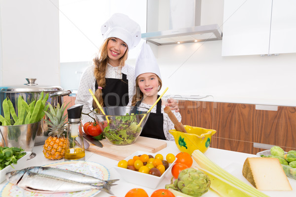 Kid girls junior chef friends hug together in countertop Stock photo © lunamarina